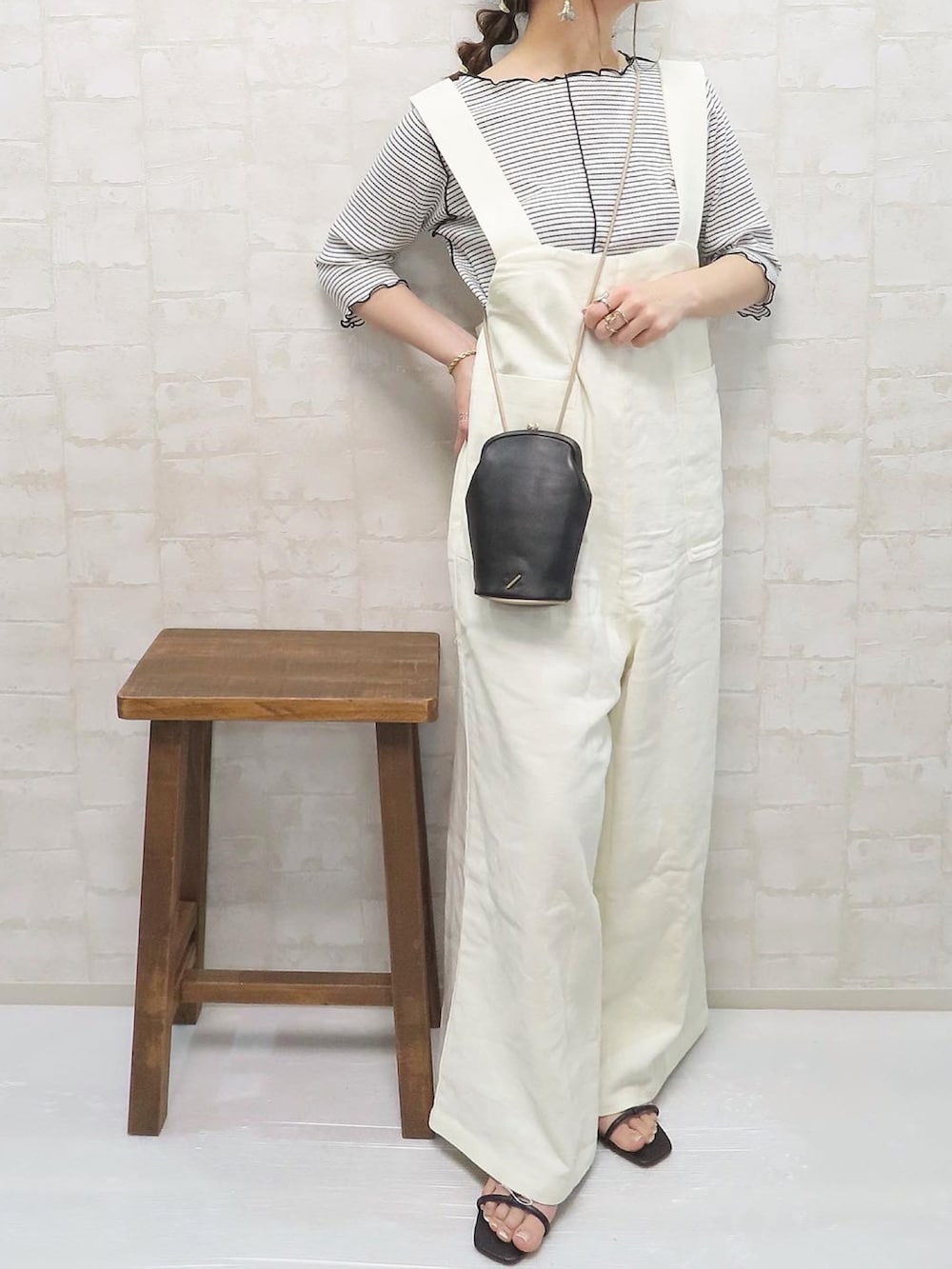 ホワイト系のサロペット/オーバーオール、ホワイト系のTシャツ/カットソー、ブラック系のショルダーバッグを着用したレディースの春コーディネートの4枚目の写真