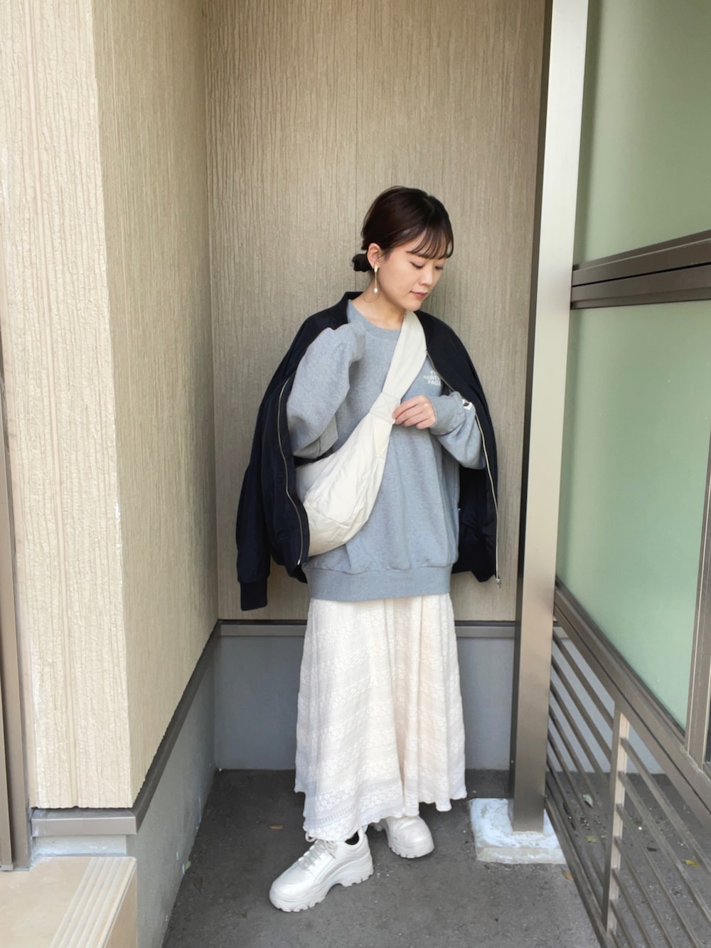 ブラック系のブルゾン、グレー系のスウェット、ホワイト系のショルダーバッグを着用したレディースの春コーディネートの2枚目の写真