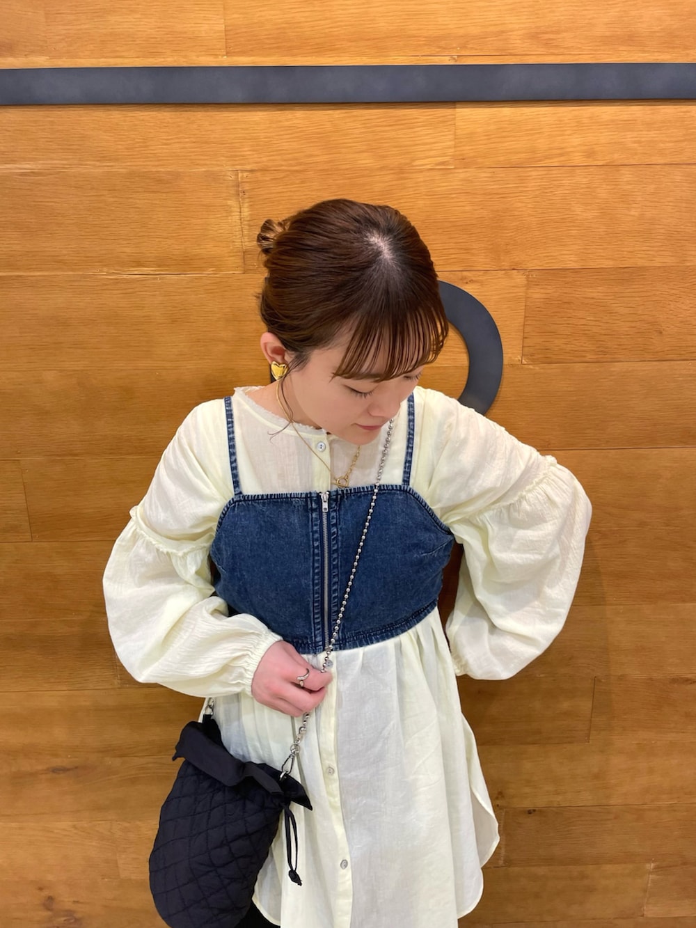 イエロー系のシャツ/ブラウス、ブルー系のトップス、ブラック系のスカートを着用したレディースの春コーディネートの3枚目の写真