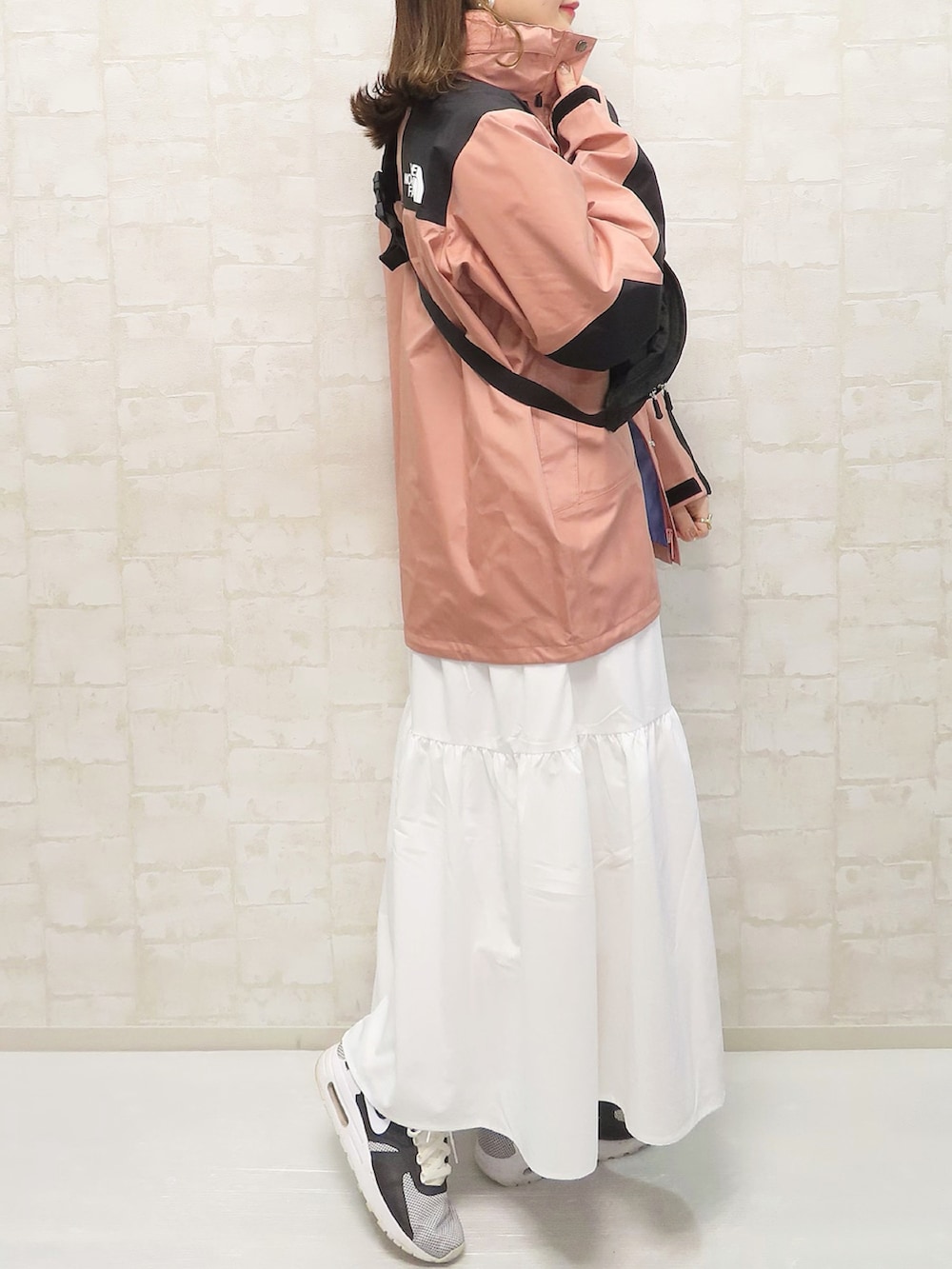 ピンク系のマウンテンパーカー、ホワイト系のTシャツ/カットソー、ホワイト系のスカートを着用したレディースの春コーディネートの3枚目の写真