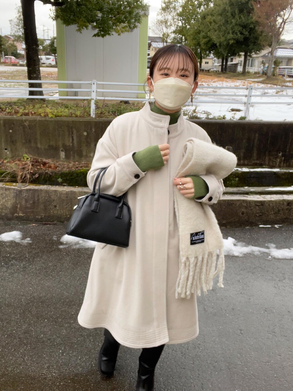 ホワイト系のその他アウター、グリーン系のニット/セーター、ブラック系のボストンバッグを着用したレディースの冬コーディネートの3枚目の写真