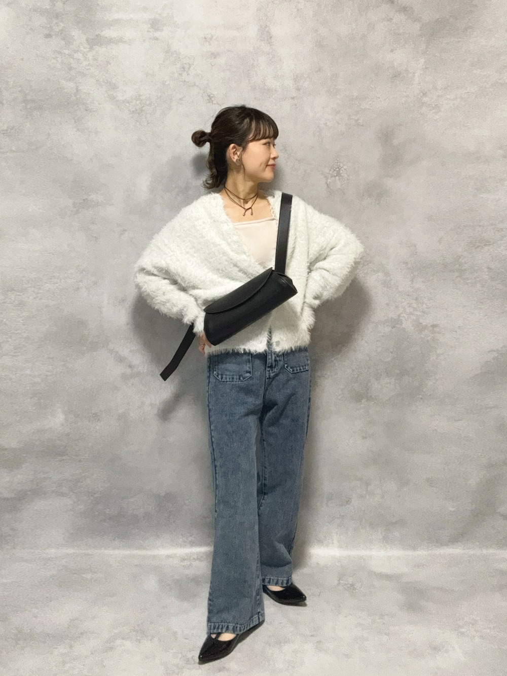 ホワイト系のニット/セーター、ブルー系のデニムパンツ、ブラック系のショルダーバッグを着用したレディースの秋コーディネートの2枚目の写真