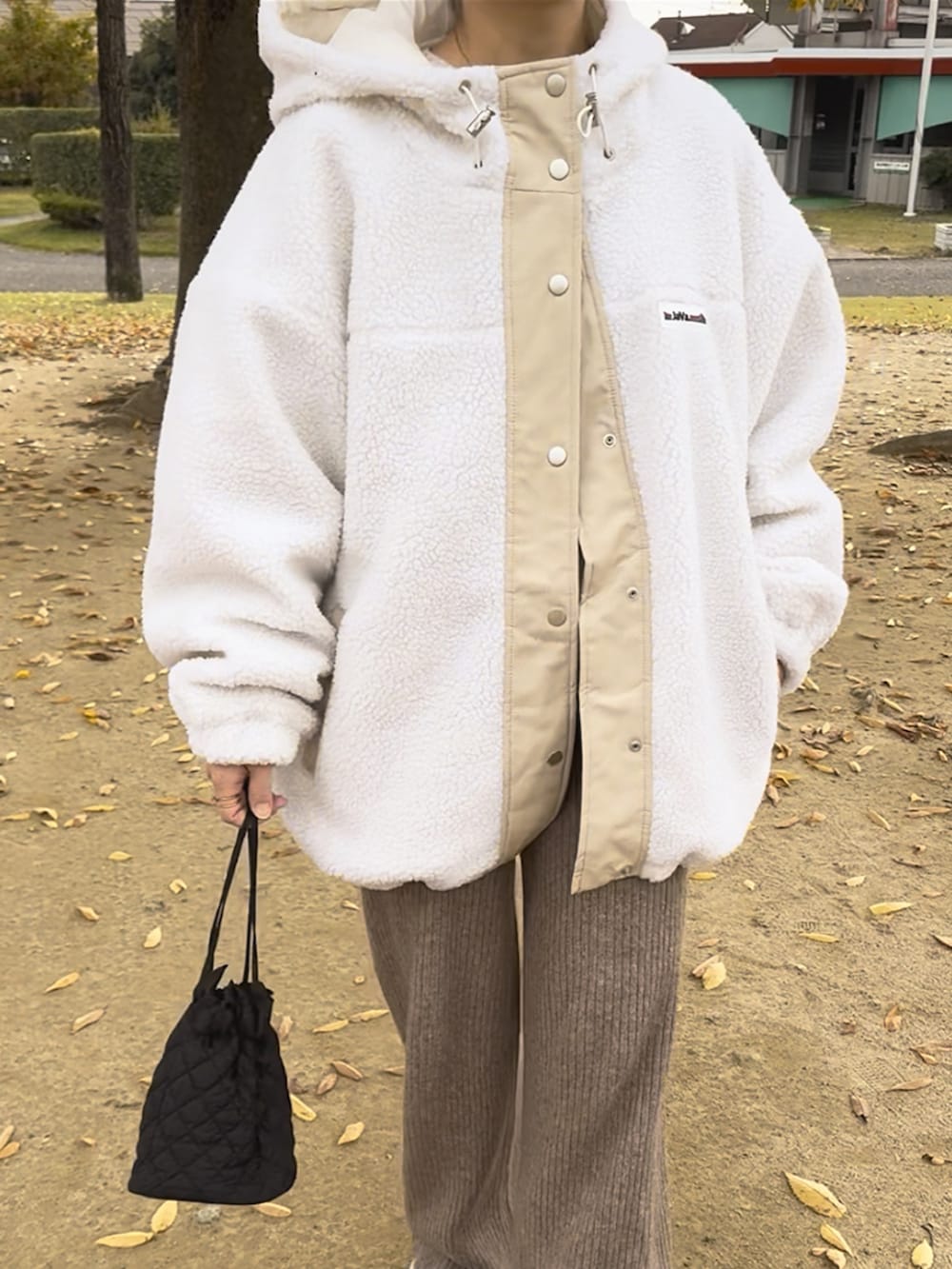 ホワイト系のブルゾン、ブラウン系のその他パンツ、ホワイト系のニット/セーターを着用したレディースの冬コーディネートの4枚目の写真