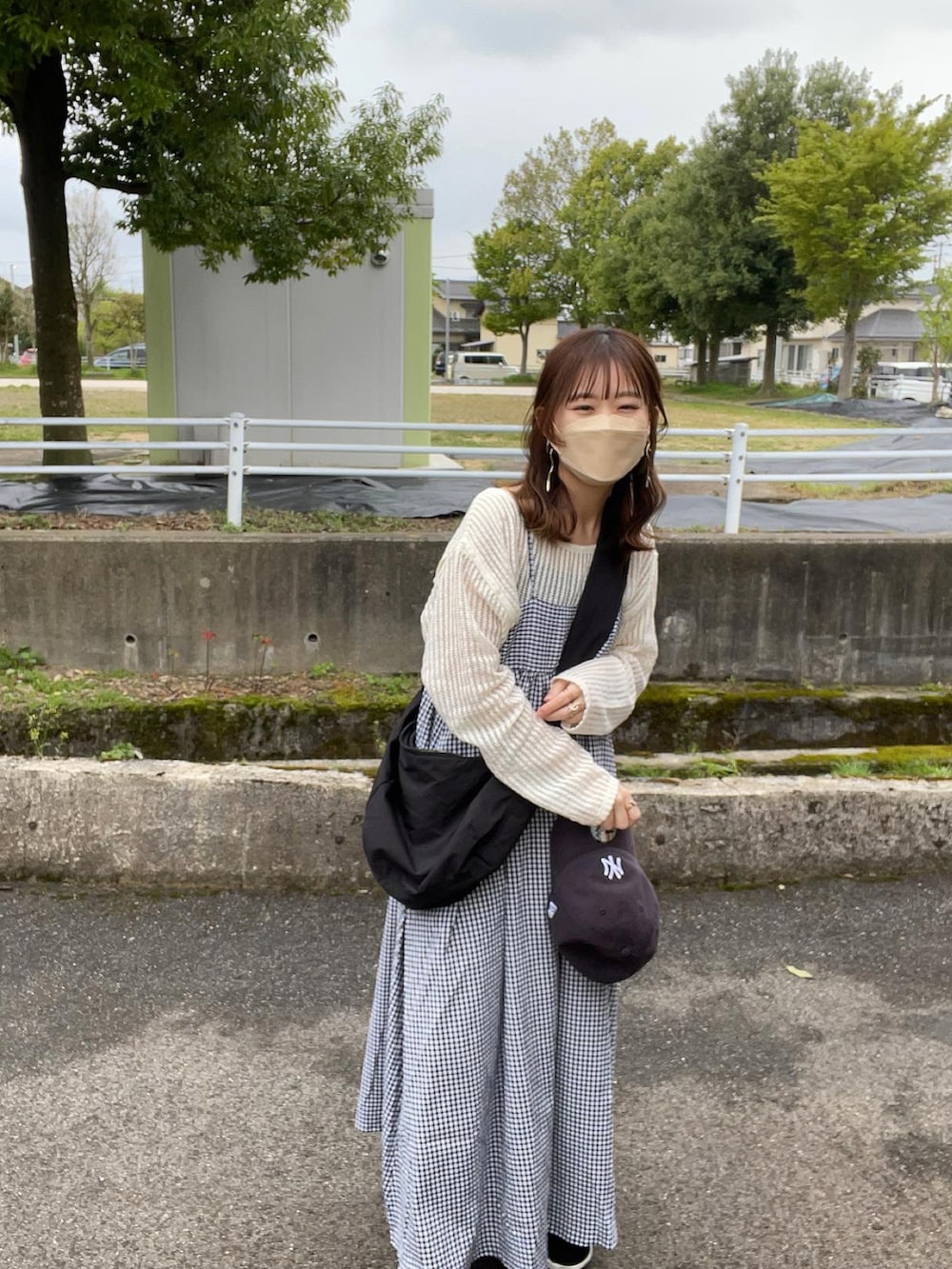 ホワイト系のワンピース、ベージュ系のTシャツ/カットソー、ブラック系のキャミソールを着用したレディースの春コーディネートの4枚目の写真