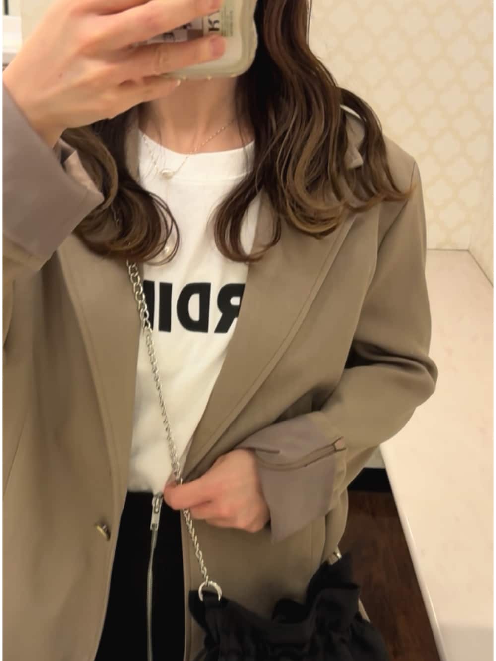 ベージュ系のテーラードジャケット、ホワイト系のTシャツ/カットソー、ブラック系のショルダーバッグを着用したレディースの春コーディネートの4枚目の写真