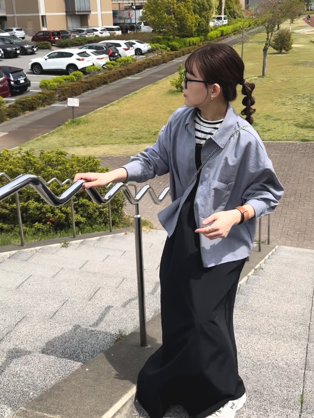 ブラック系のワンピース、ブルー系のシャツ/ブラウス、ホワイト系のスニーカーを着用したレディースの春コーディネートの2枚目の写真