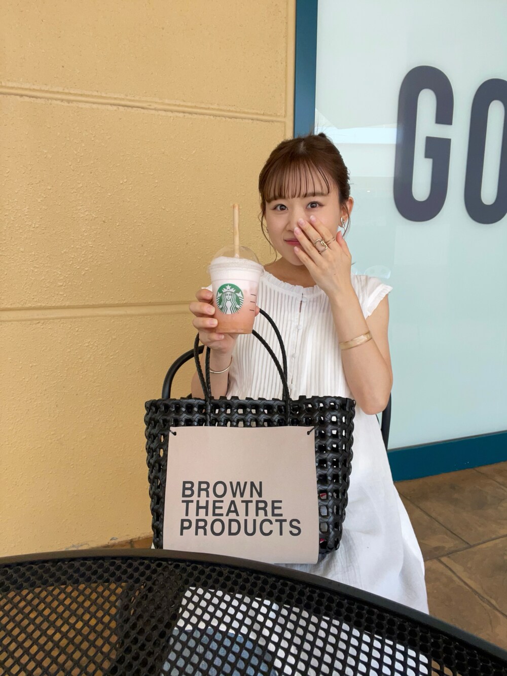 ホワイト系のトップス、ブルー系のデニムパンツ、ブラック系のハンドバッグを着用したレディースの夏コーディネートの5枚目の写真