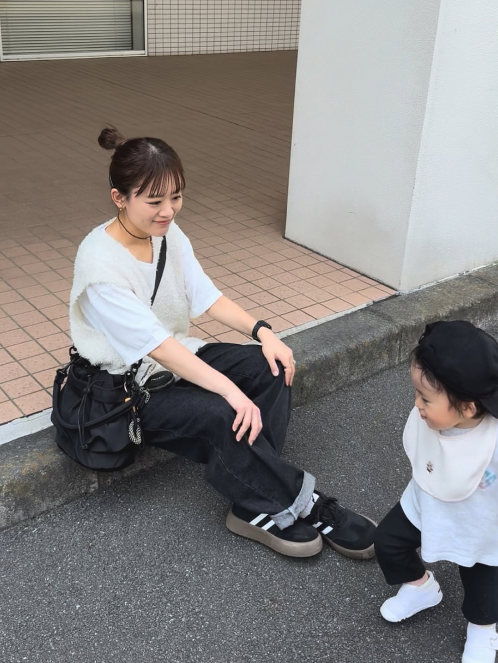 ホワイト系のトップス、ブラック系のパンツ、ブラック系のバッグを着用したレディースの秋コーディネートの2枚目の写真