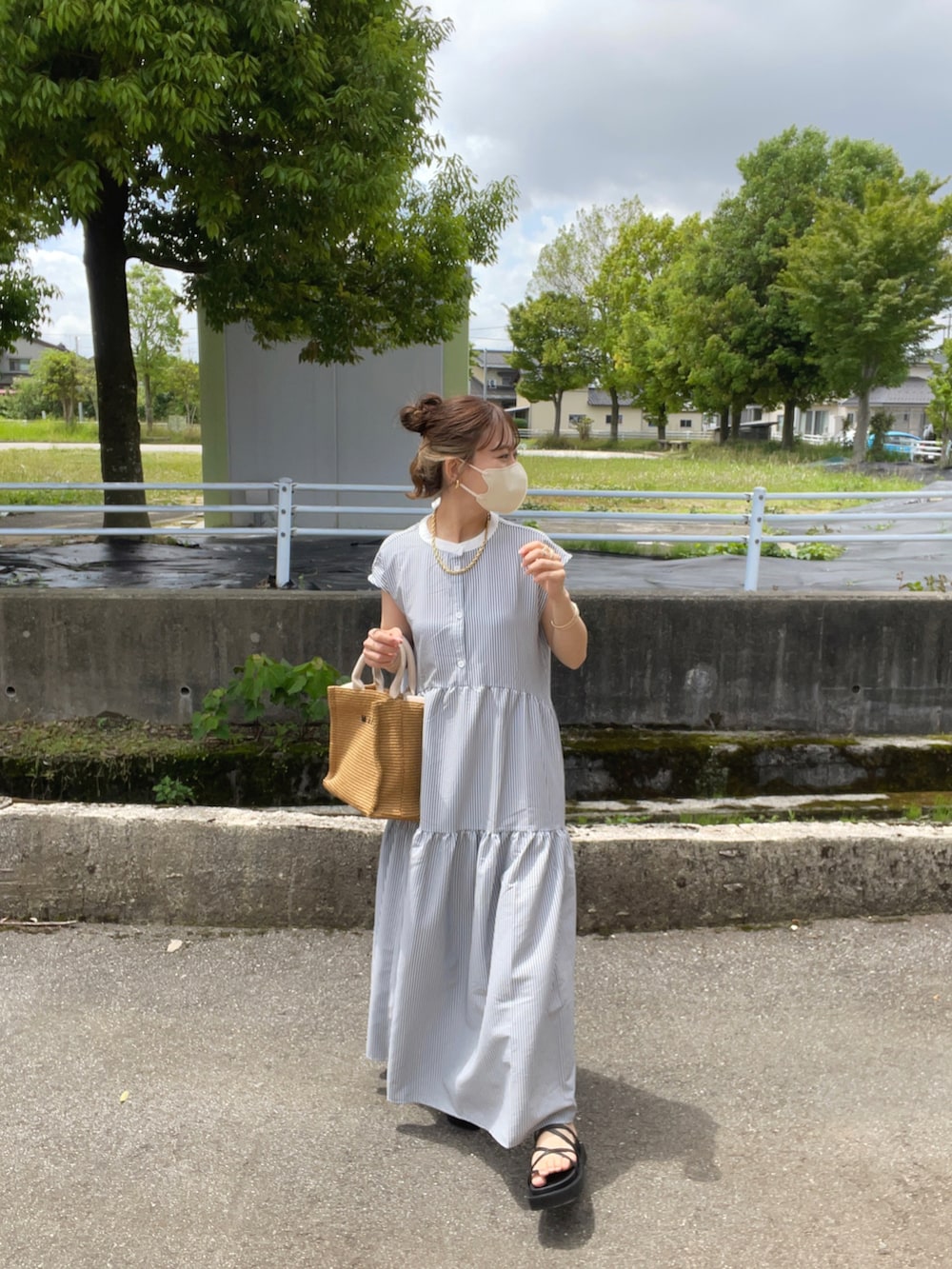 ブラック系のワンピース、ベージュ系のショルダーバッグ、ブラック系のサンダルを着用したレディースの夏コーディネートの5枚目の写真