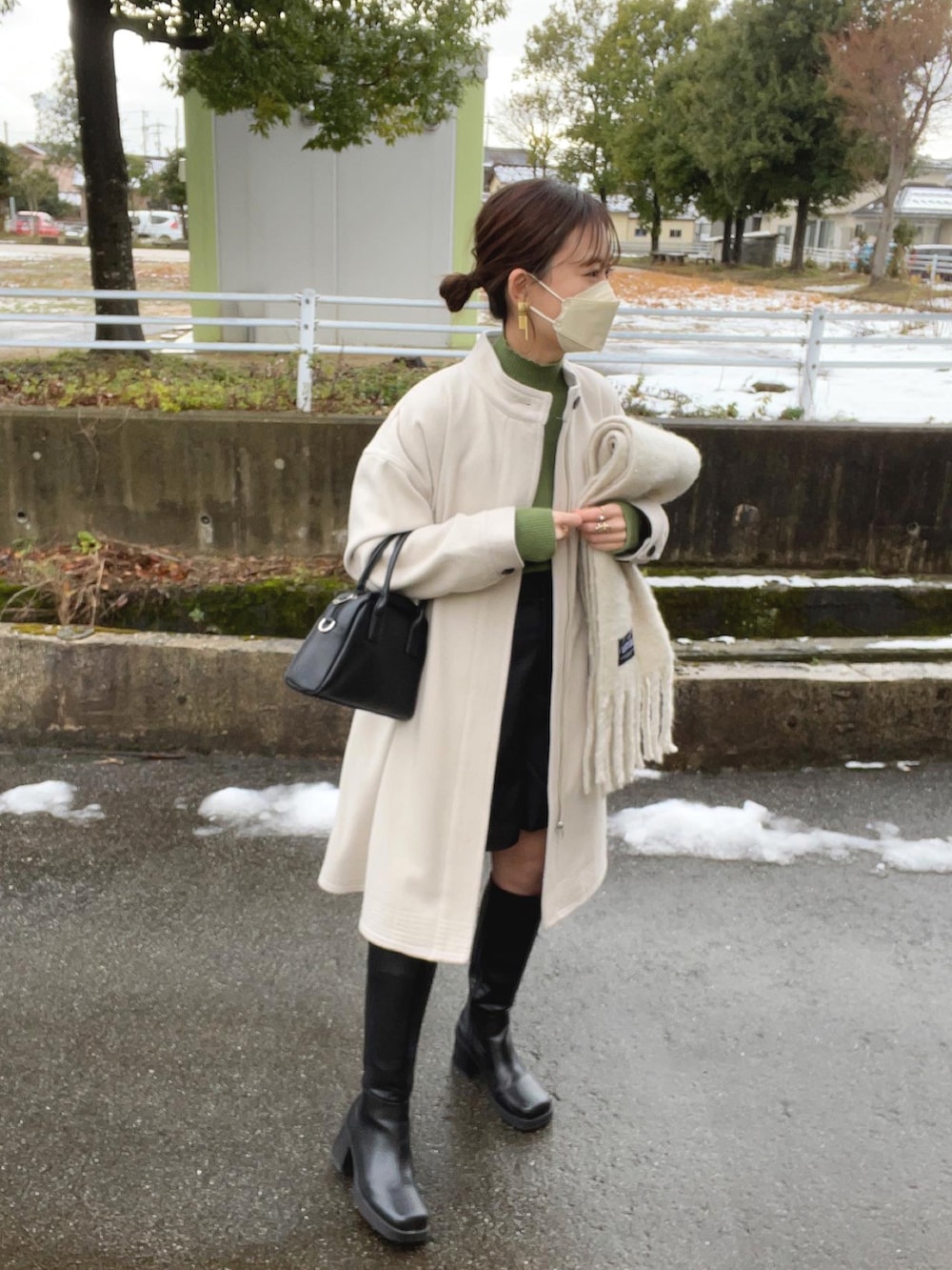 ホワイト系のその他アウター、グリーン系のニット/セーター、ブラック系のボストンバッグを着用したレディースの冬コーディネートの2枚目の写真