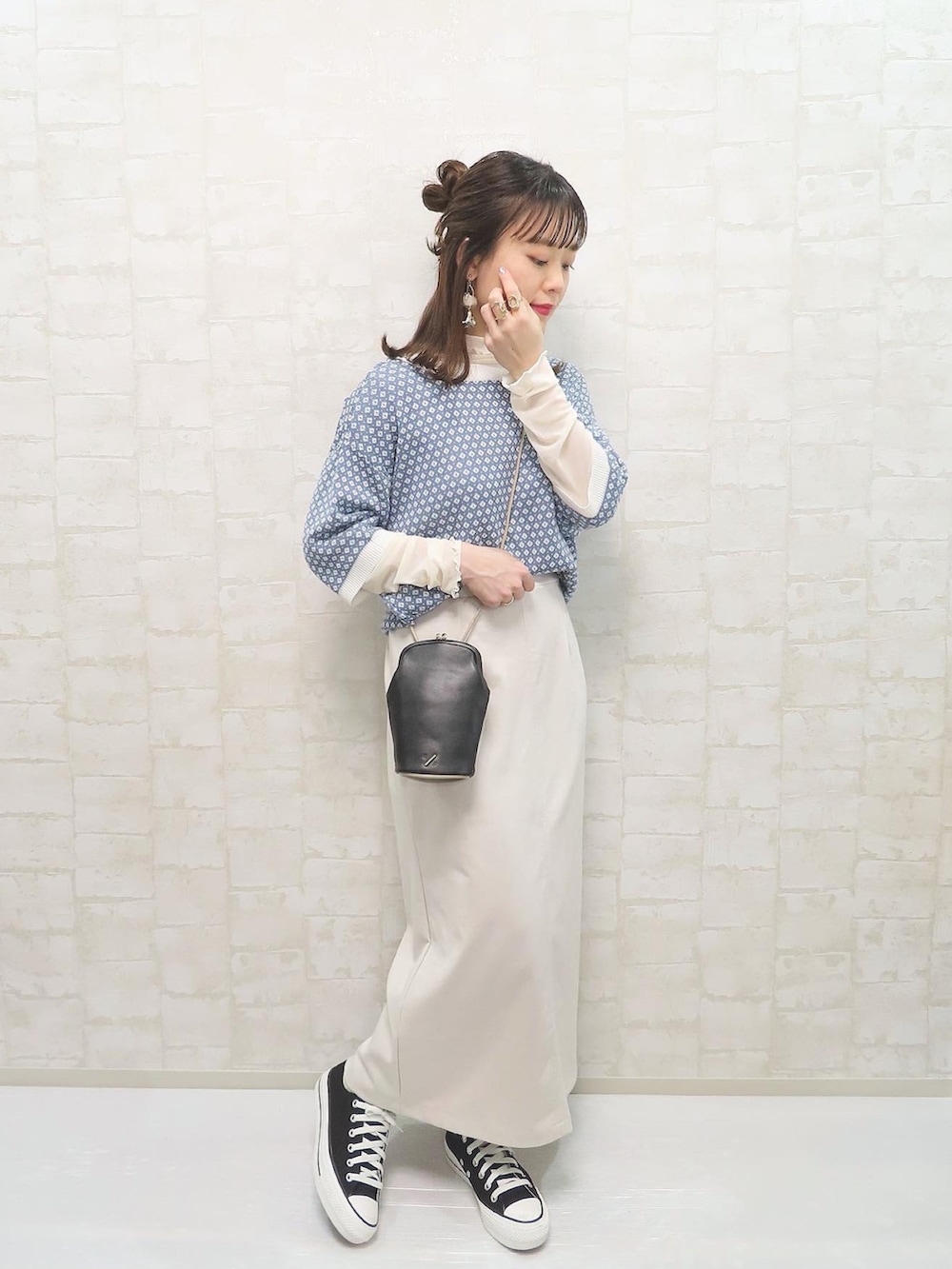 ブルー系のカーディガン/ボレロ、ブラック系のデニムパンツ、ホワイト系のスニーカーを着用したレディースの春コーディネートの2枚目の写真