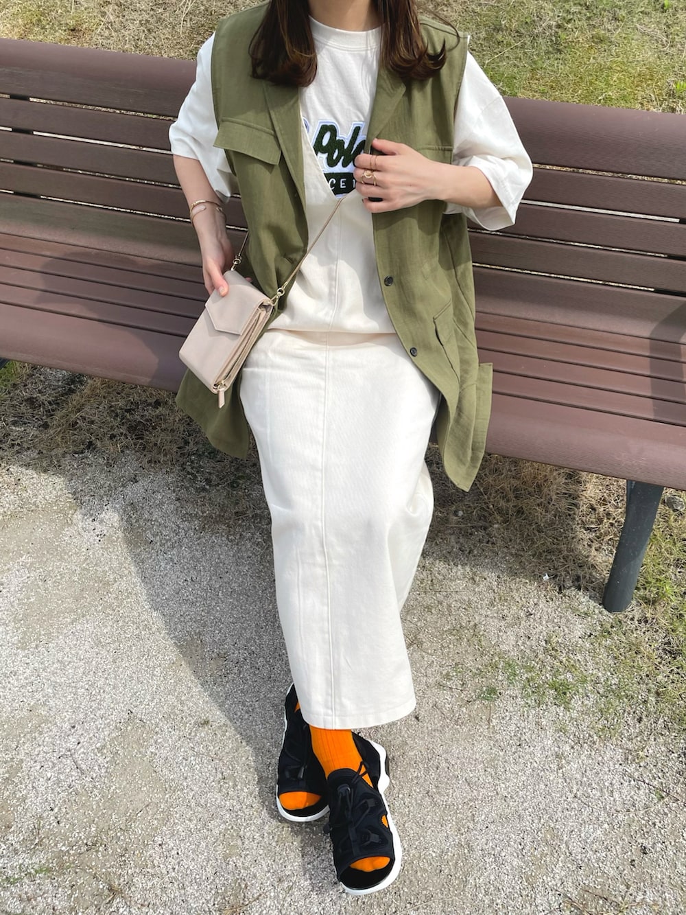 ベージュ系のTシャツ/カットソー、ホワイト系のジャンパースカート、グリーン系のベストを着用したレディースの夏コーディネートの3枚目の写真