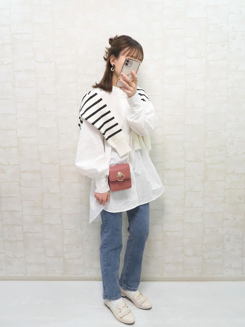 ホワイト系のシャツ/ブラウス、ホワイト系のカーディガン/ボレロ、ブルー系のデニムパンツを着用したレディースの春コーディネートの3枚目の写真