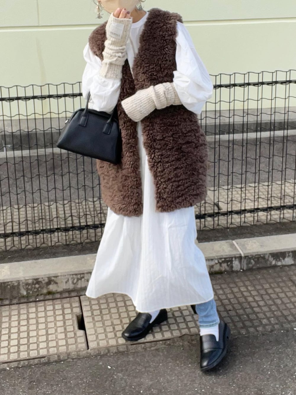 ホワイト系のシャツワンピース、ブラウン系のその他アウター、ブルー系のデニムパンツを着用したレディースの秋コーディネートの3枚目の写真