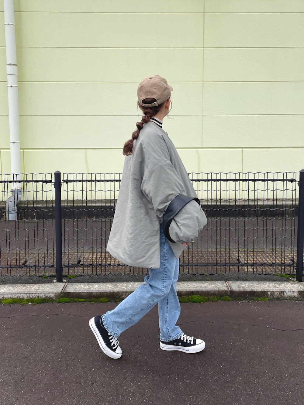 グリーン系のノーカラージャケット、ホワイト系のトップス、ブルー系のデニムパンツを着用したレディースの冬コーディネートの4枚目の写真