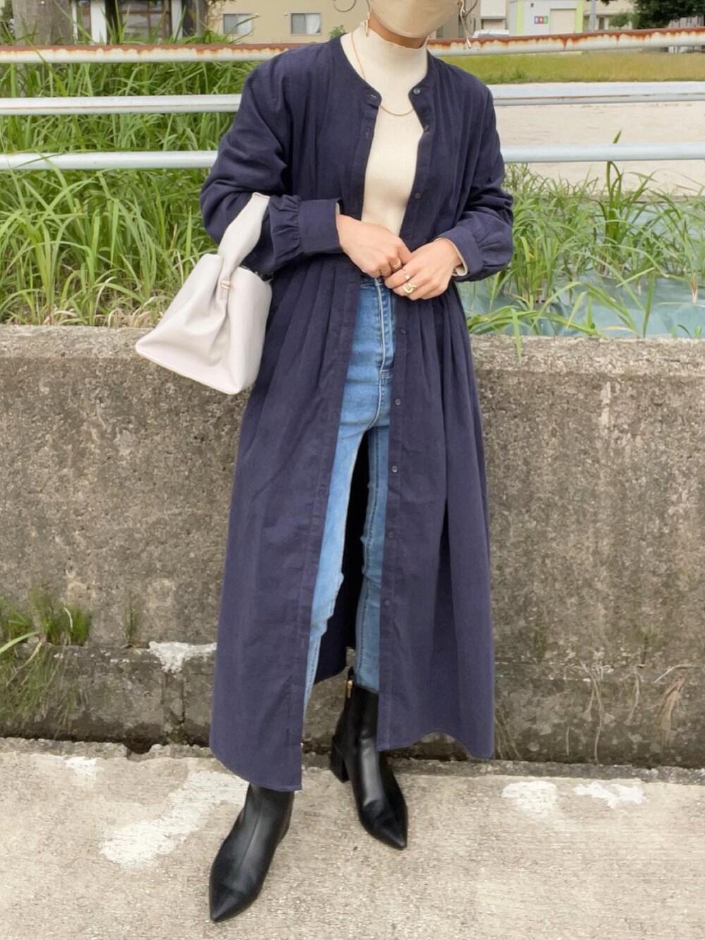 ブルー系のワンピース、ブラック系のブーツ、ホワイト系のニット/セーターを着用したレディースの秋コーディネートの4枚目の写真