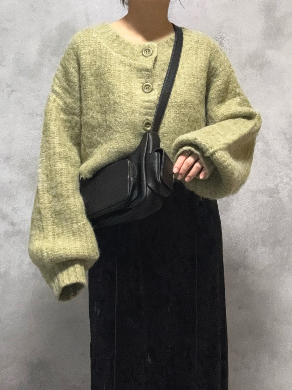 グリーン系のカーディガン/ボレロ、ブラック系のワンピース、ブラック系のショルダーバッグを着用したレディースの秋コーディネートの4枚目の写真