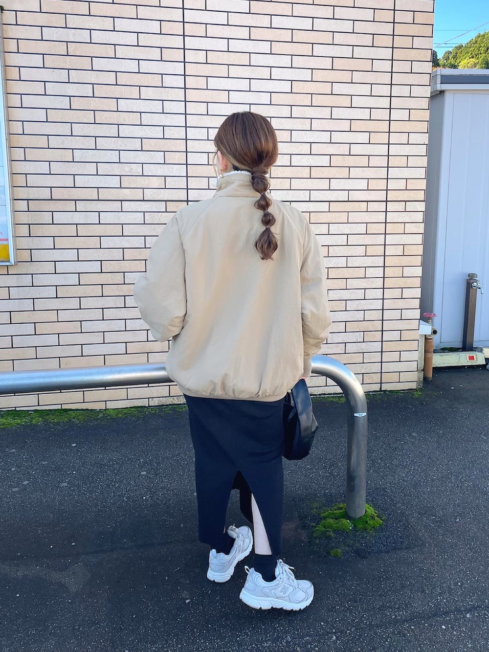 ベージュ系のブルゾン、ホワイト系のニット/セーター、ホワイト系のスニーカーを着用したレディースの冬コーディネートの2枚目の写真