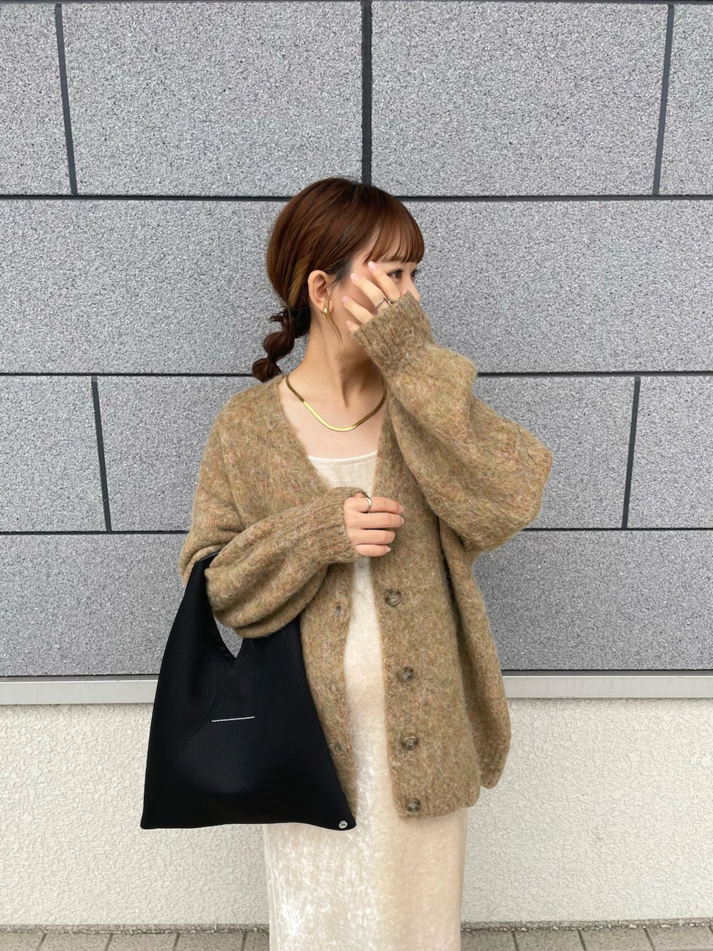 グリーン系のカーディガン/ボレロ、ホワイト系のワンピース、ブラック系のトートバッグを着用したレディースの秋コーディネートの2枚目の写真