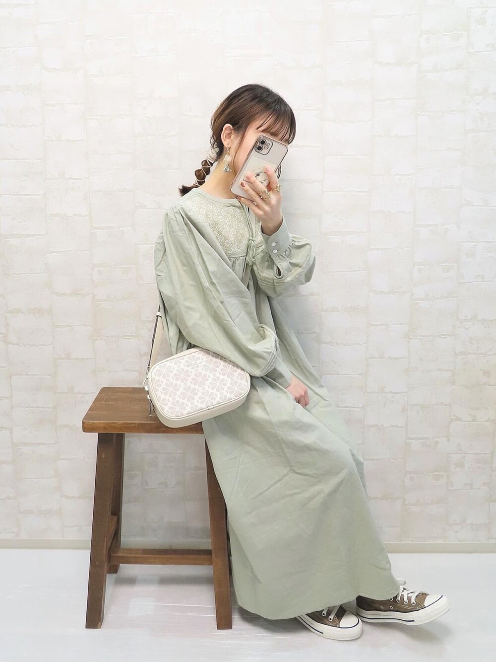 グリーン系のワンピース、ホワイト系のショルダーバッグ、ブラウン系のスニーカーを着用したレディースの春コーディネートの4枚目の写真