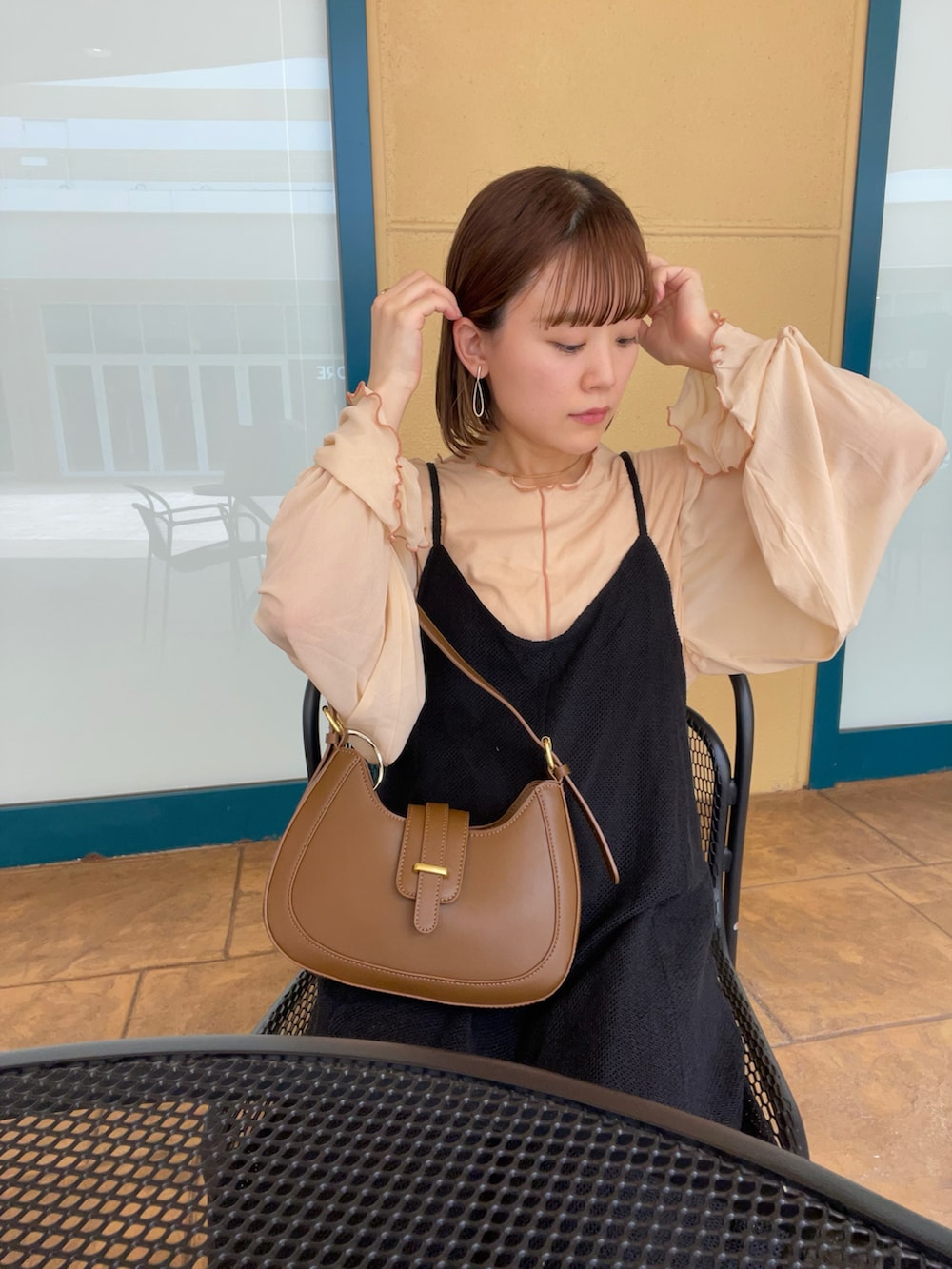 ベージュ系のTシャツ/カットソー、ブラック系のワンピース、ブラウン系のバッグを着用したレディースの夏コーディネートの2枚目の写真