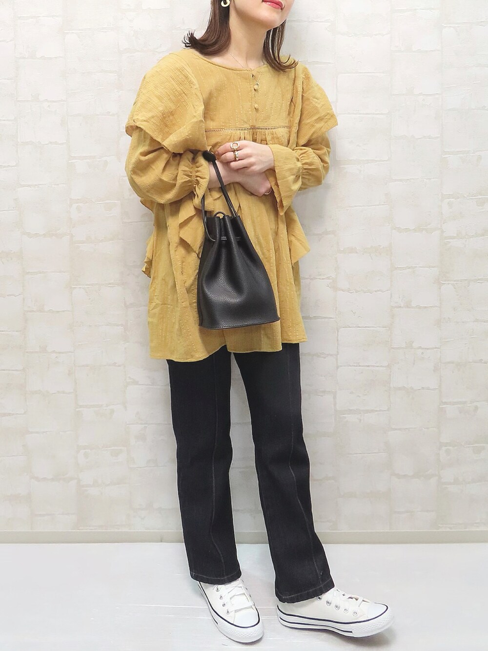 イエロー系のシャツ/ブラウス、ブルー系のデニムパンツ、ホワイト系のスニーカーを着用したレディースの冬コーディネートの2枚目の写真