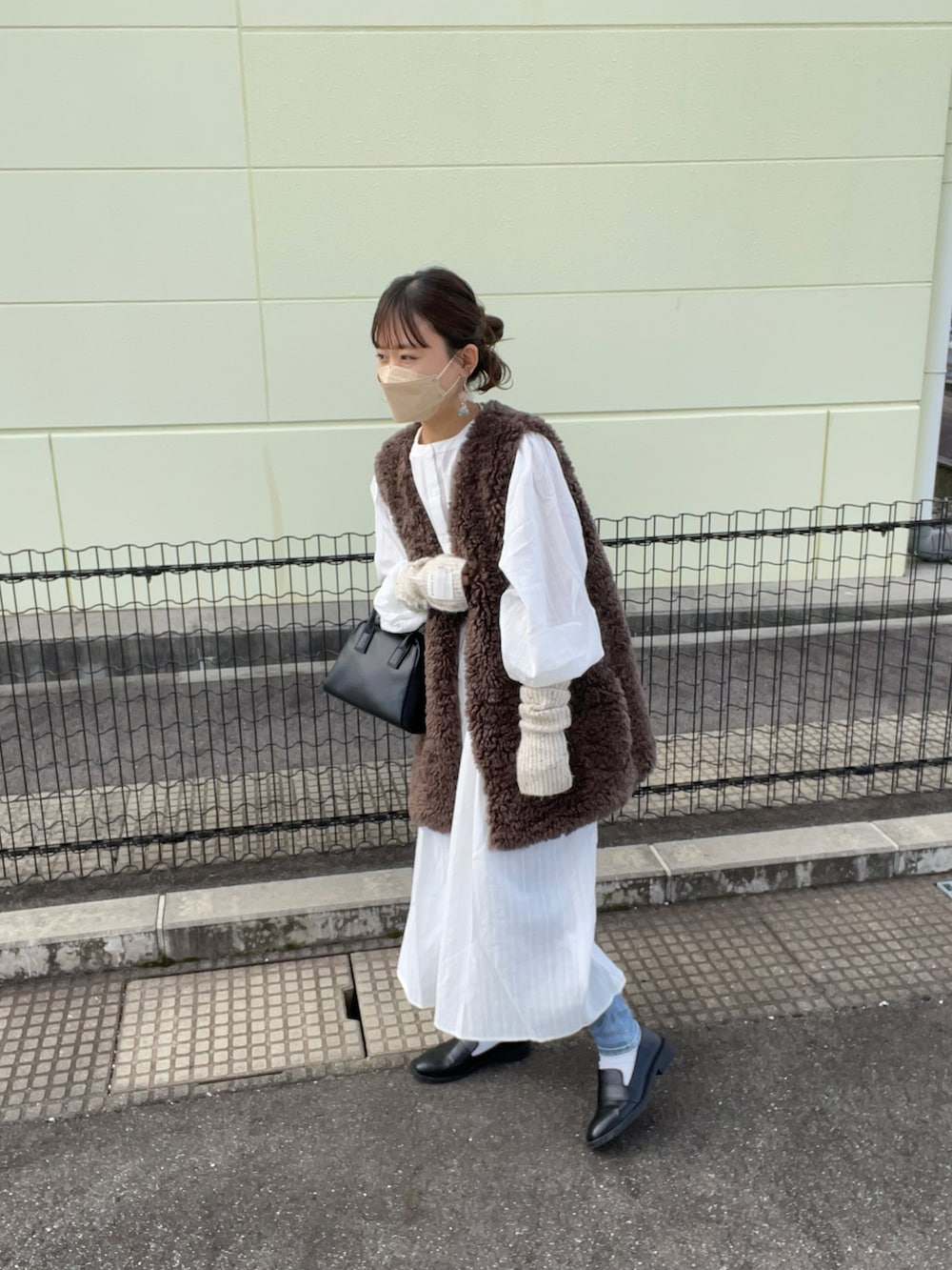 ホワイト系のシャツワンピース、ブラウン系のその他アウター、ブルー系のデニムパンツを着用したレディースの秋コーディネートの5枚目の写真