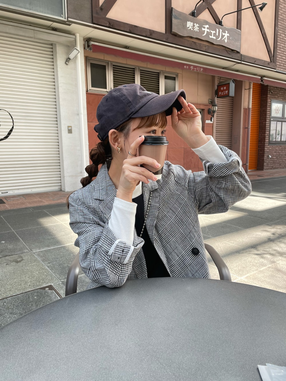 ブラック系のテーラードジャケット、ブラック系のワンピース、ブラック系のショルダーバッグを着用したレディースの春コーディネートの3枚目の写真