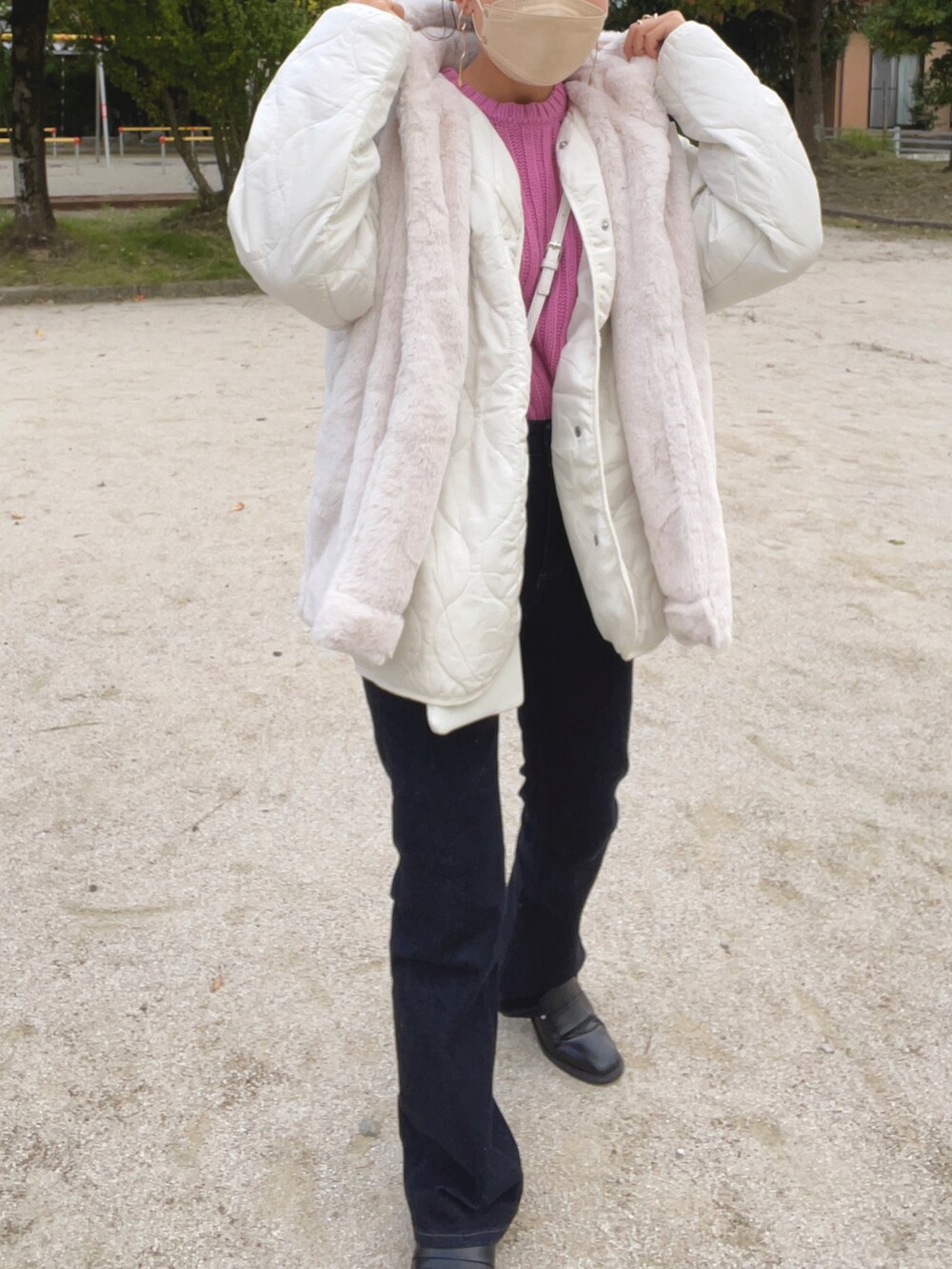 ピンク系のニット/セーター、ホワイト系のジャケット/アウター、ブルー系のデニムパンツを着用したレディースの秋コーディネートの3枚目の写真