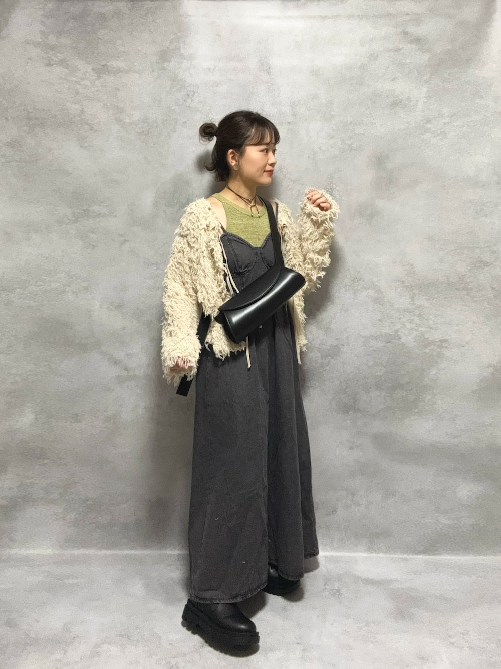 グリーン系のタンクトップ、ブラック系のワンピース/ドレス、ホワイト系のカーディガン/ボレロを着用したレディースの秋コーディネートの5枚目の写真