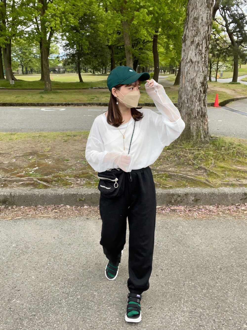 ホワイト系のTシャツ/カットソー、ブラック系のスウェットパンツ、ブラック系のショルダーバッグを着用したレディースの春コーディネートの2枚目の写真