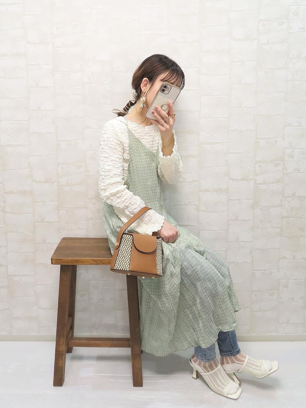 グリーン系のワンピース、ホワイト系のTシャツ/カットソー、ブルー系のデニムパンツを着用したレディースの春コーディネートの4枚目の写真