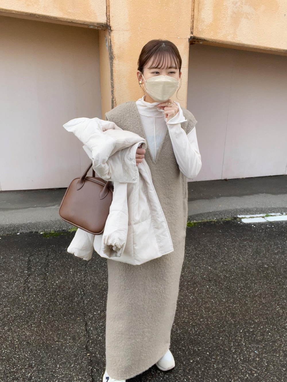 ホワイト系のTシャツ/カットソー、ブラウン系のワンピース、ホワイト系のダウンジャケット/コートを着用したレディースの冬コーディネートの4枚目の写真