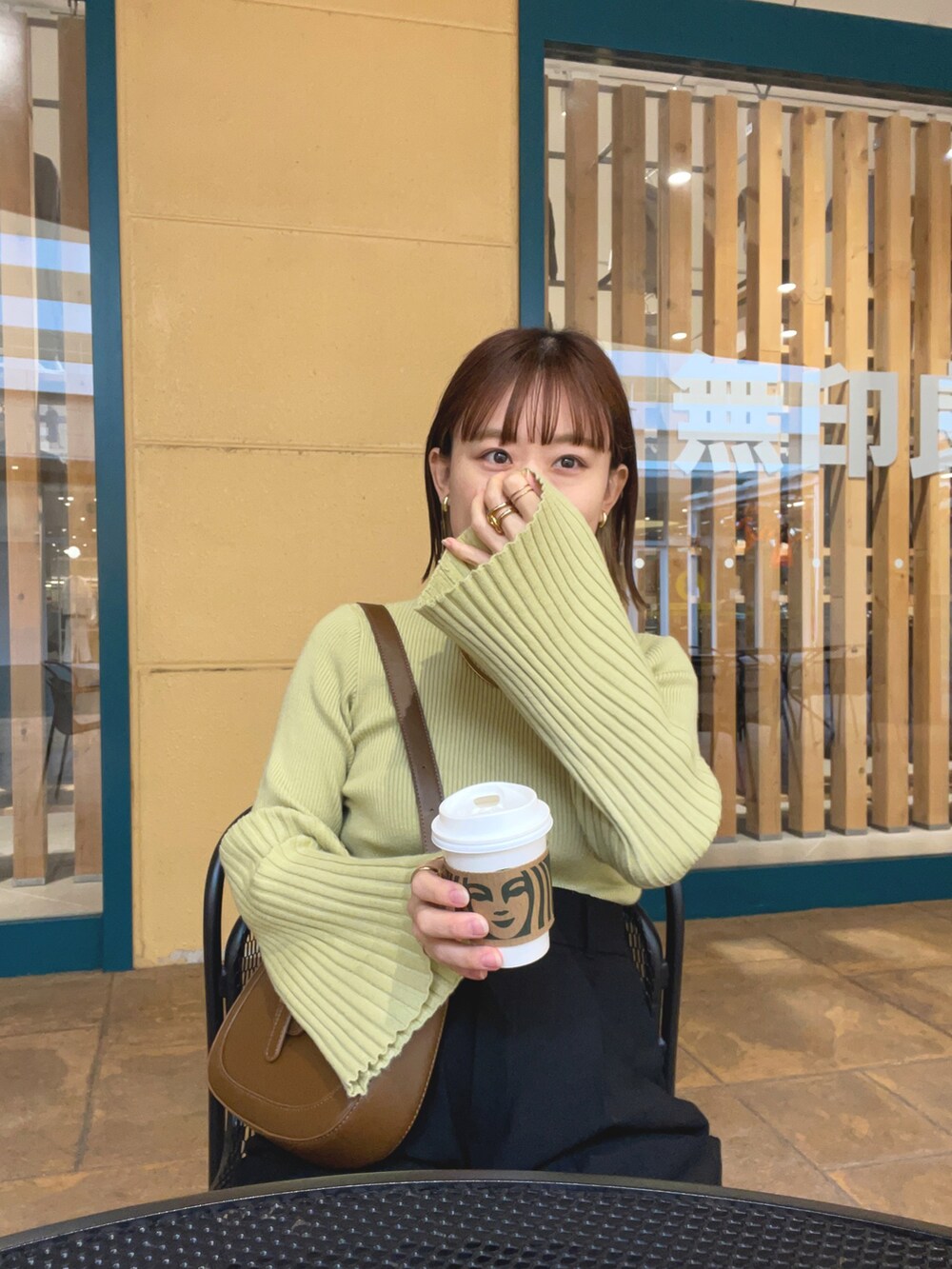 グリーン系のニット/セーター、ホワイト系のベスト、ブラック系のパンツを着用したレディースの秋コーディネートの5枚目の写真