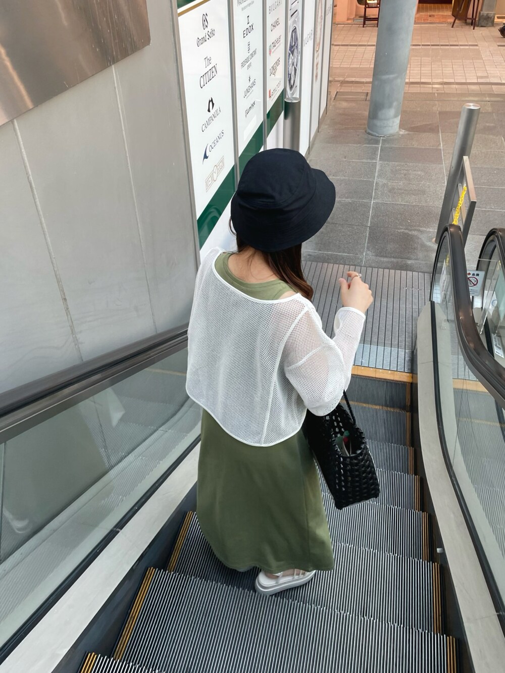 グリーン系のワンピース/ドレス、ブラック系のハンドバッグ、ホワイト系のサンダルを着用したレディースの夏コーディネートの3枚目の写真