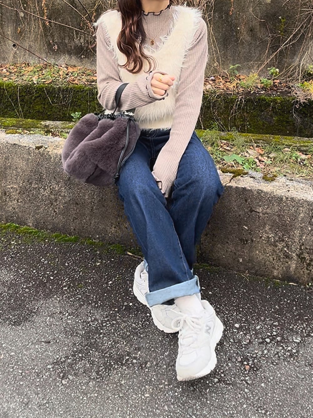 ブラウン系のニット/セーター、ホワイト系のスニーカー、ホワイト系のベストを着用したレディースの冬コーディネートの2枚目の写真