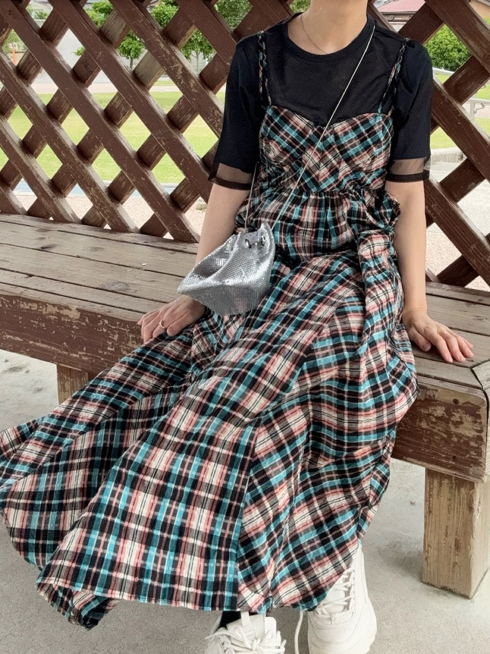 オレンジ系のワンピース、ブラック系のTシャツ/カットソー、シルバー系のバッグを着用したレディースの春コーディネートの4枚目の写真