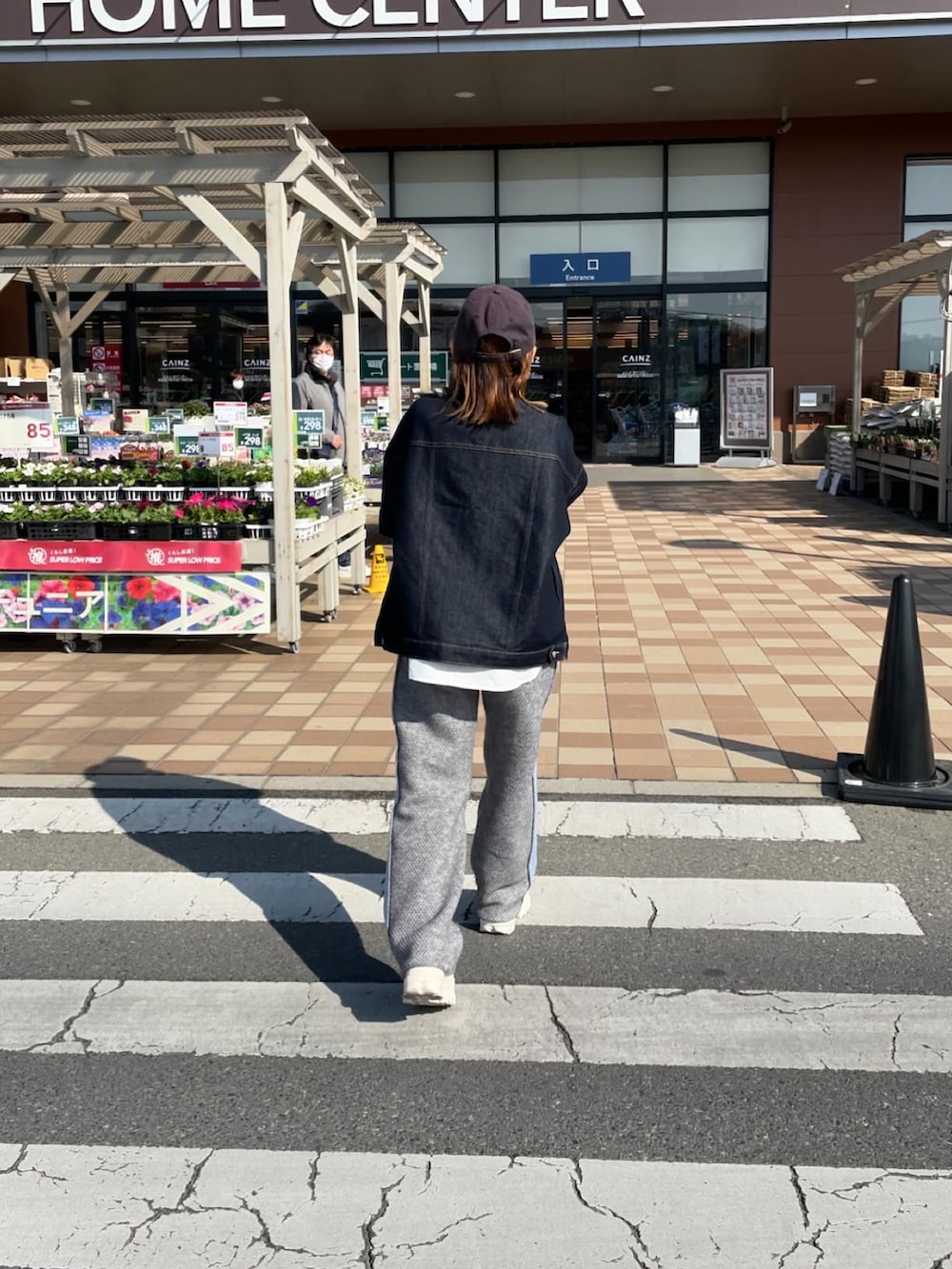ブルー系のデニムジャケット、ホワイト系のシャツ/ブラウス、グレー系のパンツを着用したレディースの春コーディネートの2枚目の写真