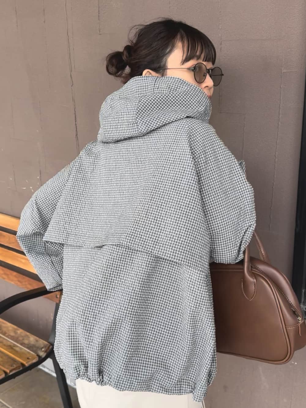 グレー系のブルゾン、ブラウン系のショルダーバッグ、ホワイト系のTシャツ/カットソーを着用したレディースの春コーディネートの3枚目の写真