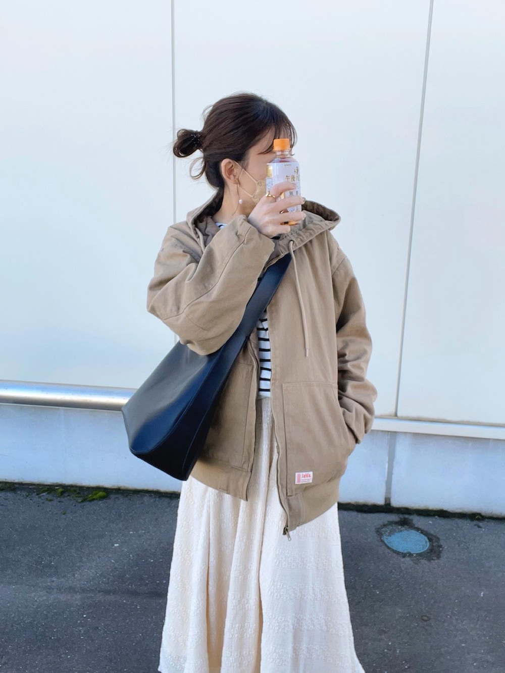 ベージュ系のブルゾン、ホワイト系のTシャツ/カットソー、ベージュ系のスカートを着用したレディースの春コーディネートの4枚目の写真