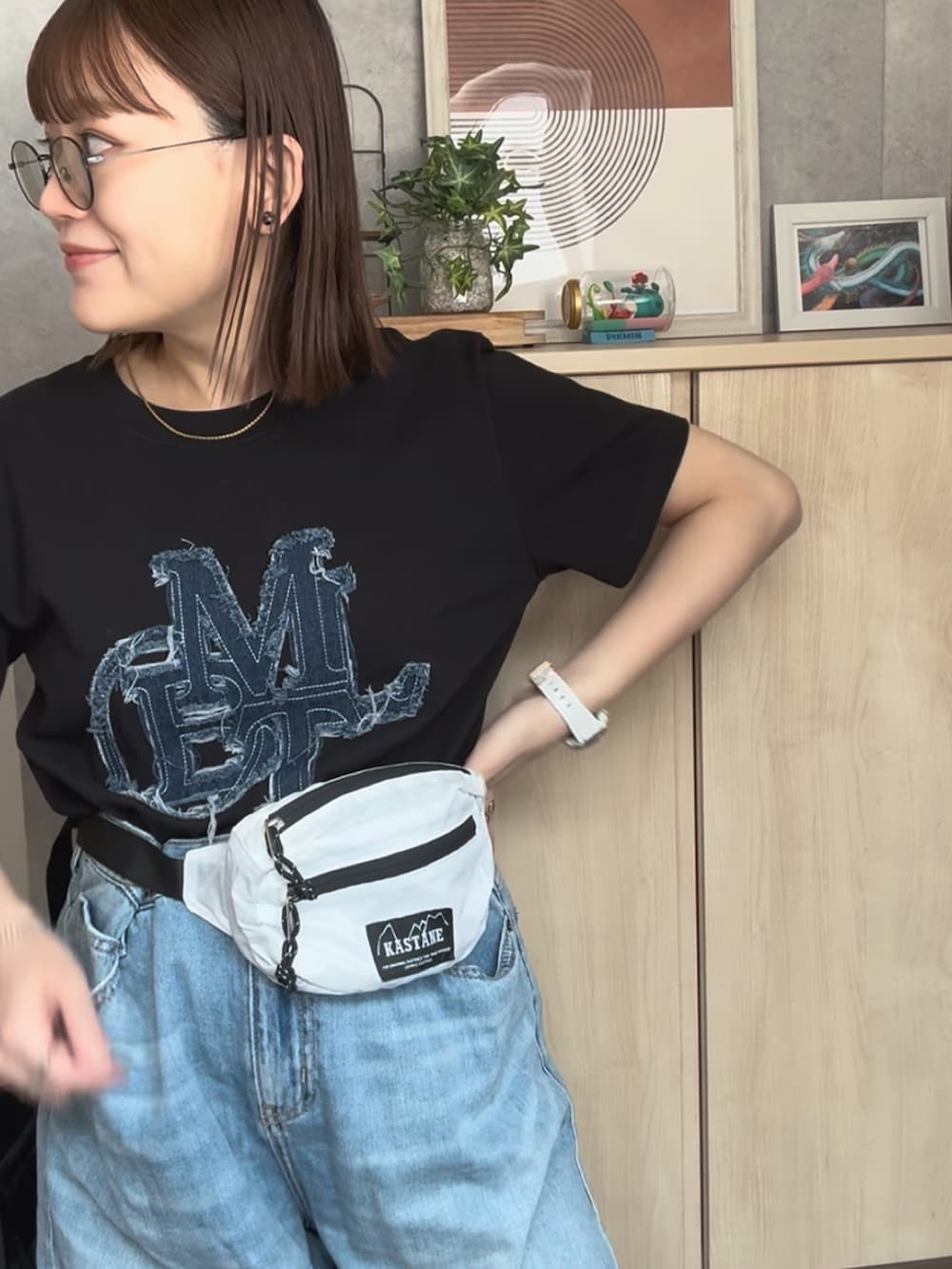 ブラック系のTシャツ/カットソー、ホワイト系のデニムスカート、ブラック系のバッグを着用したレディースの夏コーディネートの2枚目の写真