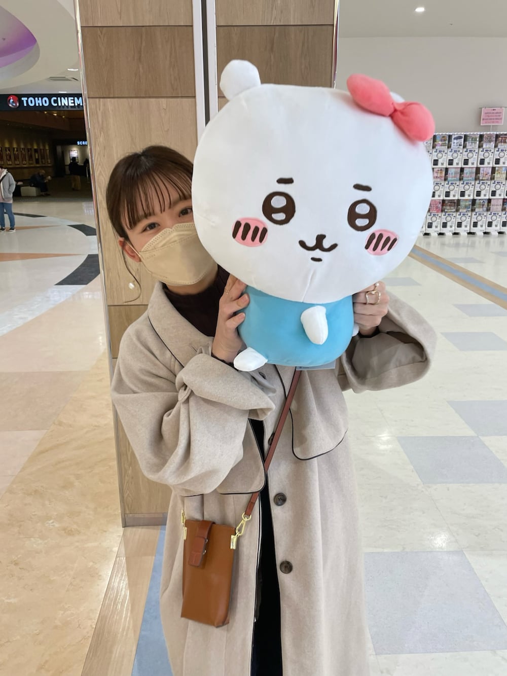 ベージュ系のジャケット/アウター、ブラウン系のニット/セーター、ブルー系のデニムパンツを着用したレディースの秋コーディネートの3枚目の写真