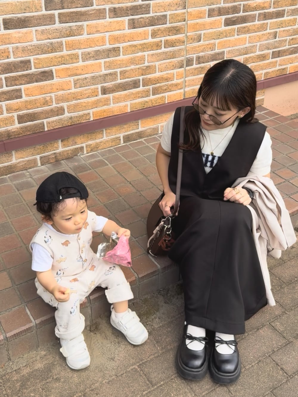 ベージュ系のテーラードジャケット、ブラック系のワンピース、ホワイト系のニット/セーターを着用したレディースの秋コーディネートの2枚目の写真