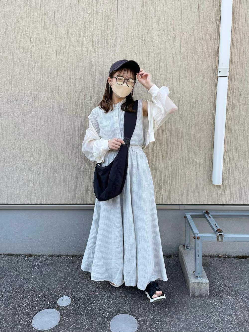 グレー系のシャツ/ブラウス、グレー系のスカート、ブラック系のショルダーバッグを着用したレディースの春コーディネートの2枚目の写真