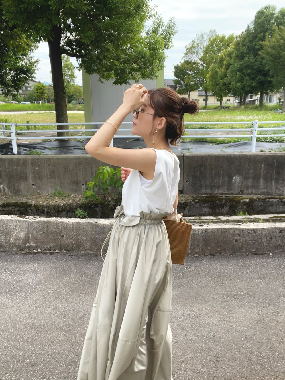 グリーン系のワンピース、ベージュ系のショルダーバッグ、ホワイト系のサンダルを着用したレディースの夏コーディネートの5枚目の写真