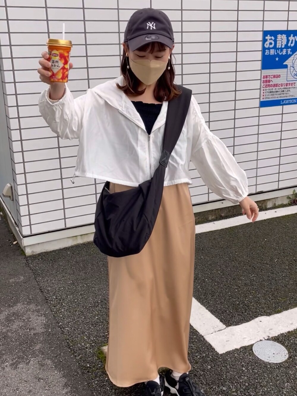 ベージュ系のスカート、ホワイト系のパーカー、ブラック系のキャミソールを着用したレディースの春コーディネートの5枚目の写真