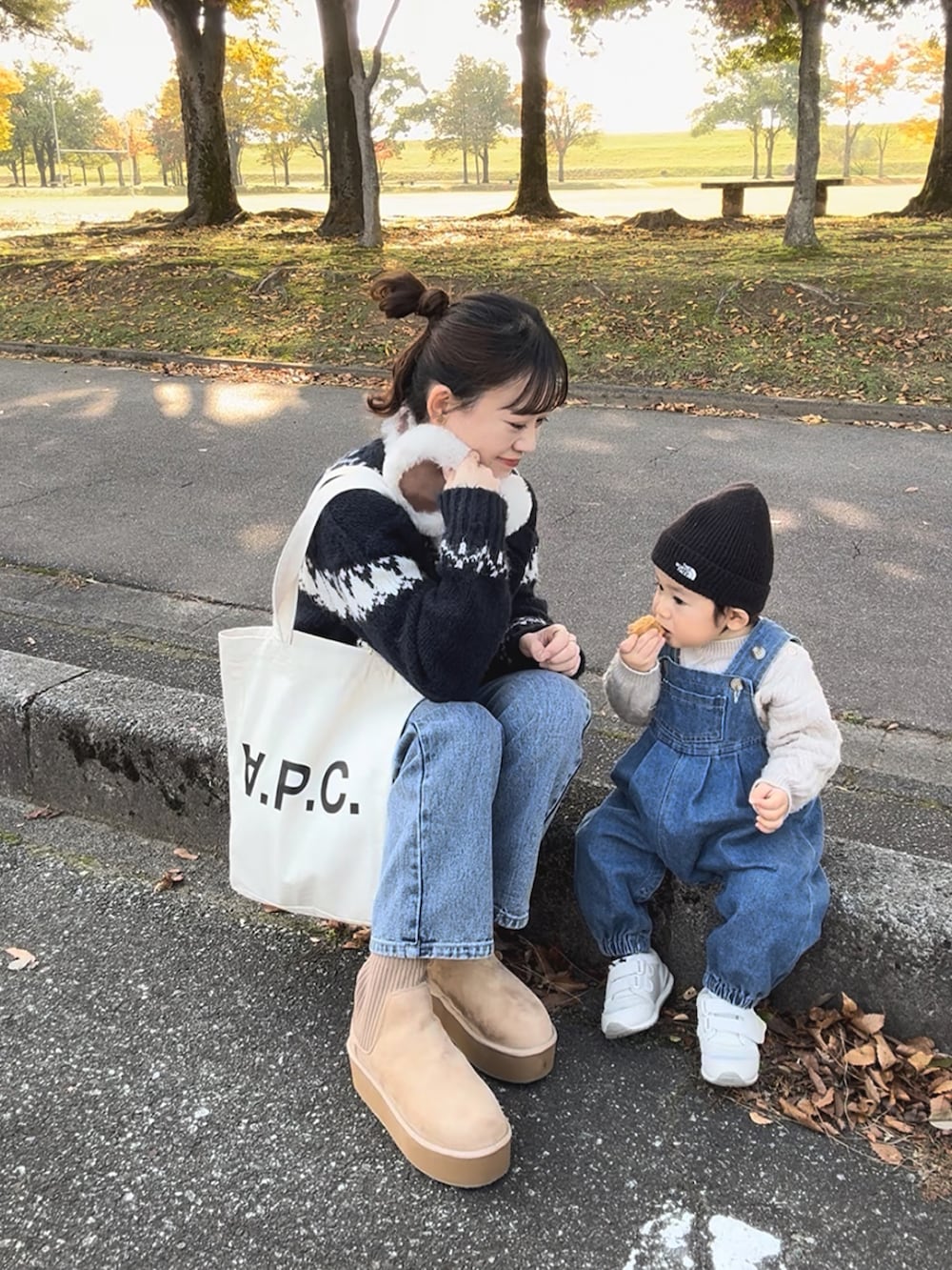 ベージュ系のブーツ、ホワイト系のトートバッグ、ブルー系のニット/セーターを着用したレディースの冬コーディネートの3枚目の写真