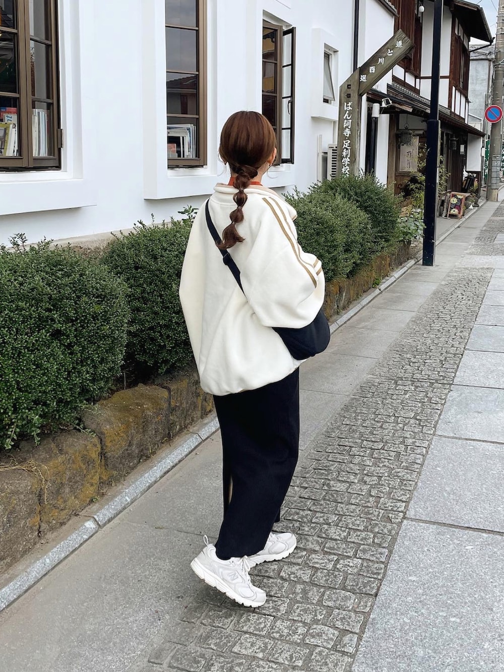 ホワイト系のスウェット、ブラウン系のニット/セーター、ブラック系のショルダーバッグを着用したレディースの秋コーディネートの4枚目の写真