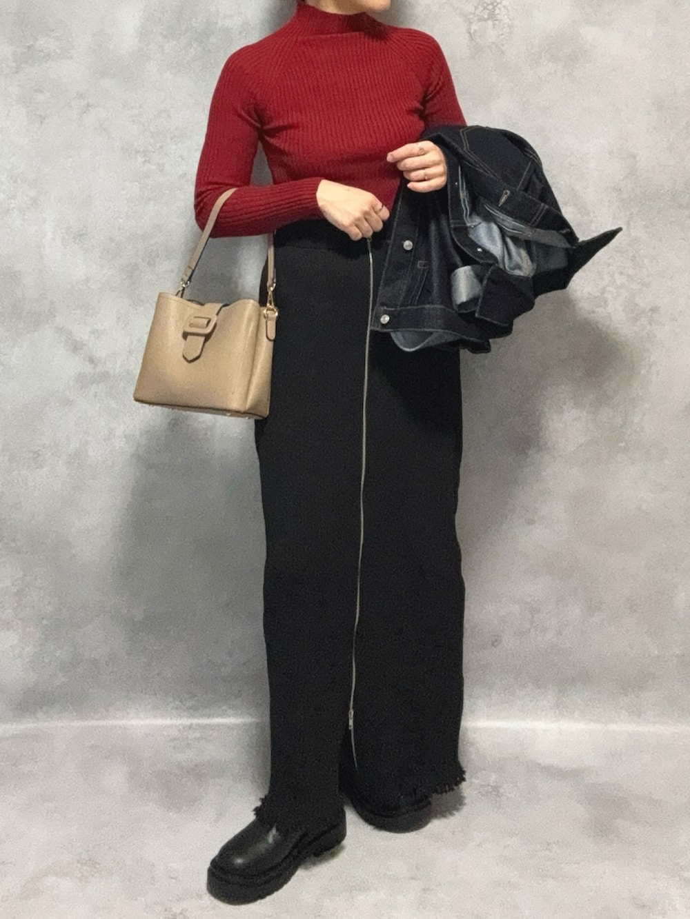 レッド系のニット/セーター、ブルー系のデニムジャケット、ブラック系のスカートを着用したレディースの秋コーディネートの5枚目の写真