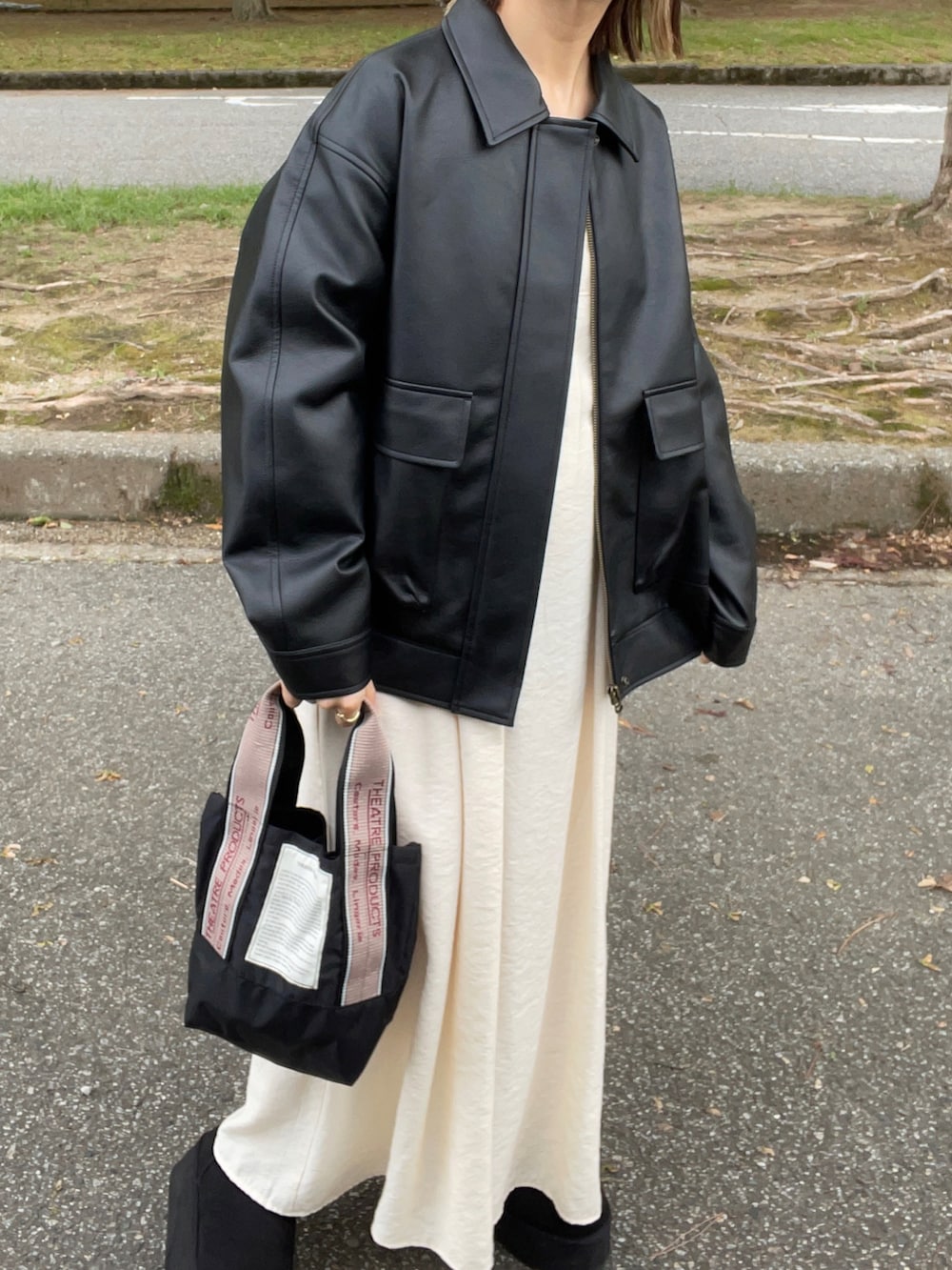 ブラック系のジャケット/アウター、ホワイト系のワンピース、ブラック系のショルダーバッグを着用したレディースの秋コーディネートの4枚目の写真